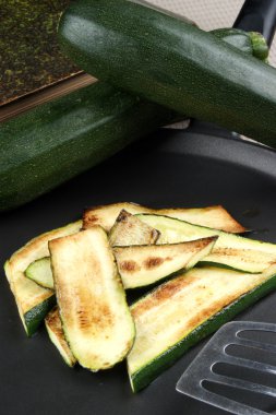 Grilled organic zucchini slices in a pan clipart