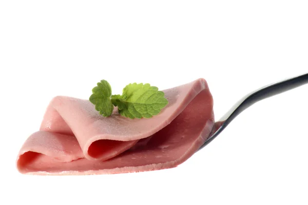 Fetta di salsiccia su una forchetta e uno sfondo bianco — Foto Stock