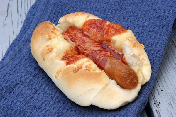 Hotdog med ketchup på en blå duk — Stockfoto