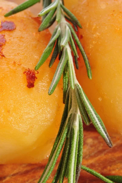 Two golden brown roasted potatoes with fresh rosemary — Stock Photo, Image