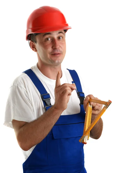 Young craftsmen in work clothes holding a ruler — Stock Photo, Image
