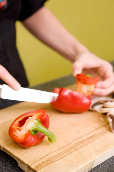 Vrouwelijke snijden een rode peper — Stockfoto