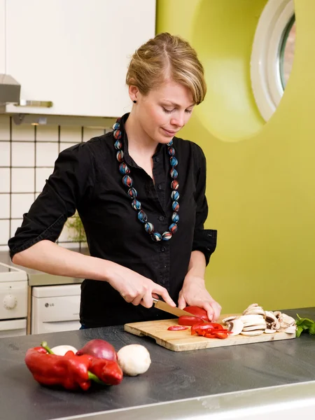 Mulher cortando legumes em casa — Fotografia de Stock