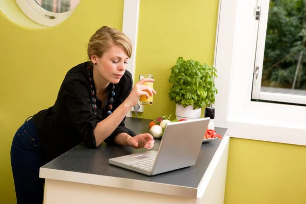 Usando laptop na cozinha — Fotografia de Stock