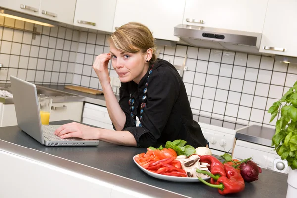 Dizüstü bilgisayar ile mutfakta yemek — Stok fotoğraf