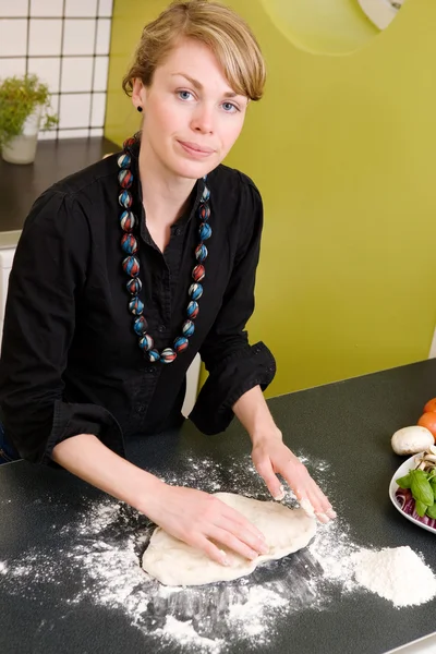 Молодая женщина делает тесто для пиццы — стоковое фото