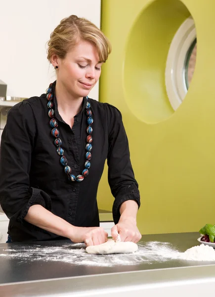 Молодая женщина с радостью делает тесто для пиццы — стоковое фото