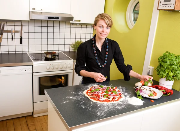 Mladá žena dělat pizzu — Stock fotografie
