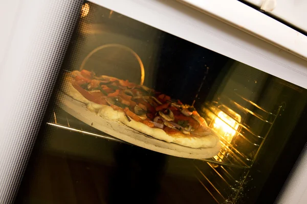 Выпечка пиццы в духовке — стоковое фото