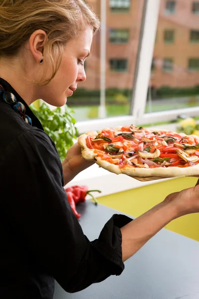 Молодая женщина со свежей пиццей — стоковое фото