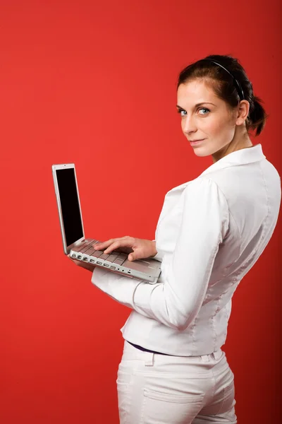 Жінка з комп'ютером на червоному — стокове фото