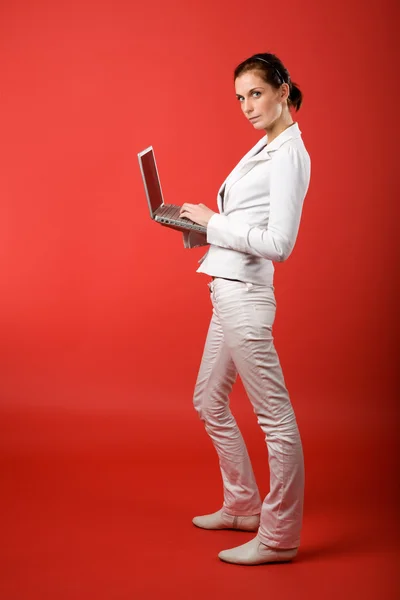 Kvinna med dator på röd — Stockfoto