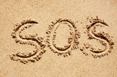 S.O.S written in the sand of an island with the ocean in the distance clipart