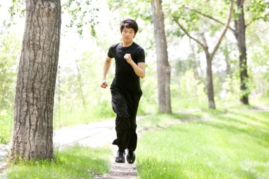 Portrait of man running in a park clipart