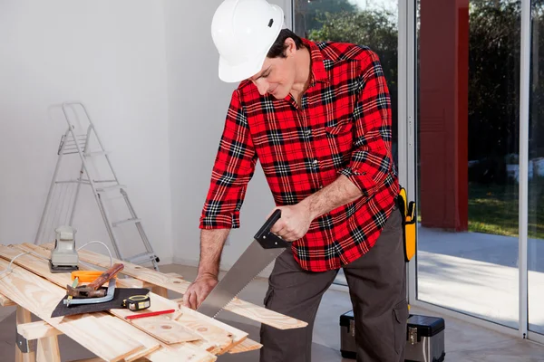 Trabajador de construcción usando sierra de mano —  Fotos de Stock