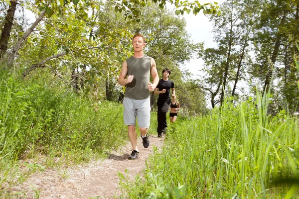Amigos se exercitando na trilha florestal — Fotografia de Stock
