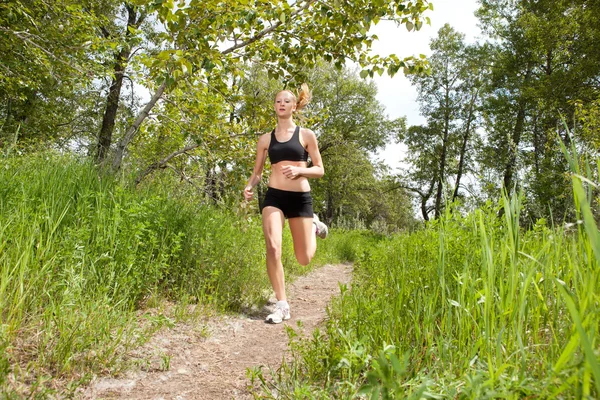 Kvinna jogging i en park — Stockfoto