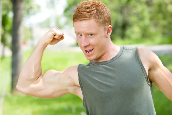 Muskulöser Mann zeigt seinen Bizeps — Stockfoto