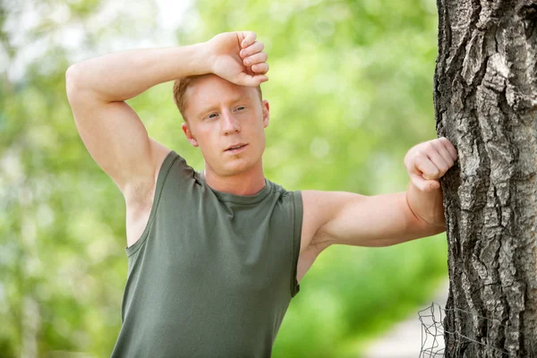 Tired man leaning on tree — Stock Photo, Image