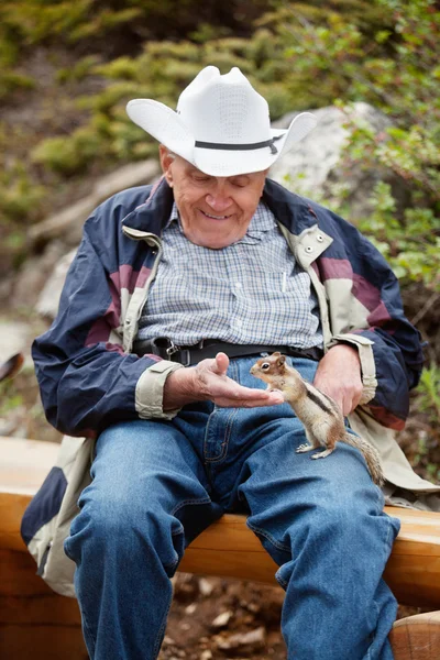 Ηλικιωμένος άνδρας παιχνίδι με σκίουρος — Φωτογραφία Αρχείου