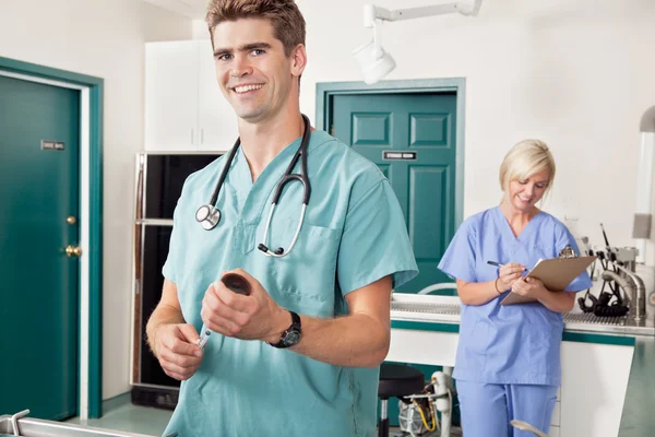 Arts met spuit terwijl verpleegster nemen van verslag — Stockfoto