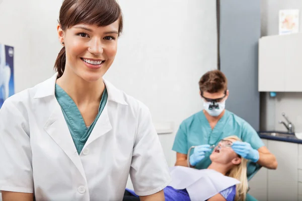 Assistent met tandheelkunde werk in de achtergrond — Stockfoto