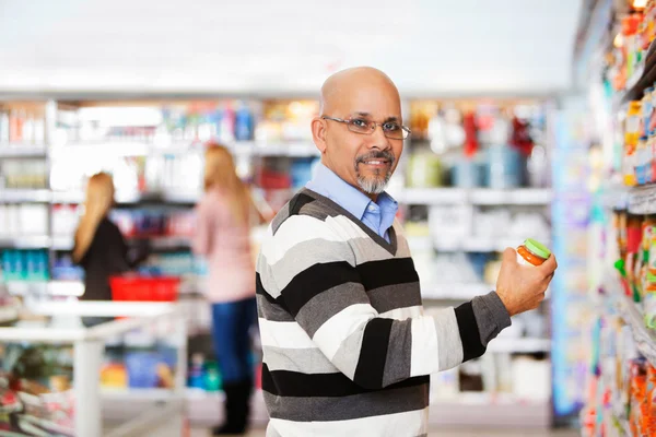 Lachende volwassen man winkelen in de supermarkt — Stockfoto