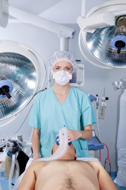 Doctor applying gas mask to a patient clipart