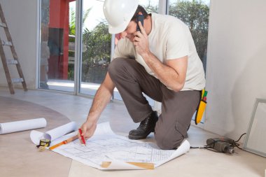 Construction worker working on blueprint clipart