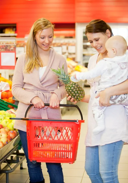 Dos amigos comprando comestibles con el bebé —  Fotos de Stock