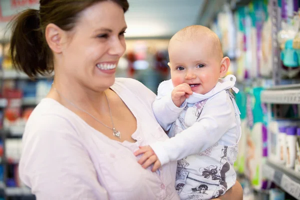 Cheerful mother and baby in shopping centre — Stock Photo, Image