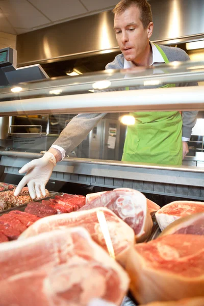 Assistente de mercado colhendo carne — Fotografia de Stock