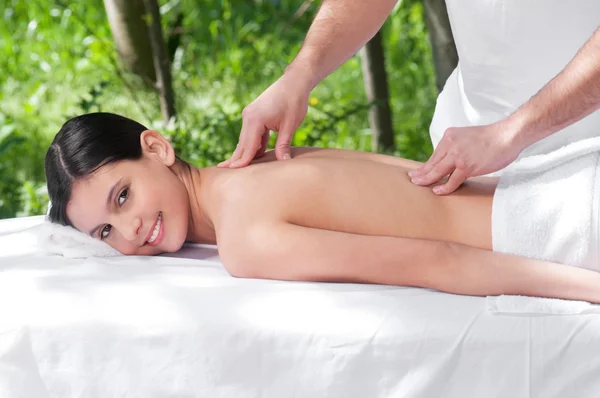 Jovem feliz recebendo massagem de um terapeuta — Fotografia de Stock