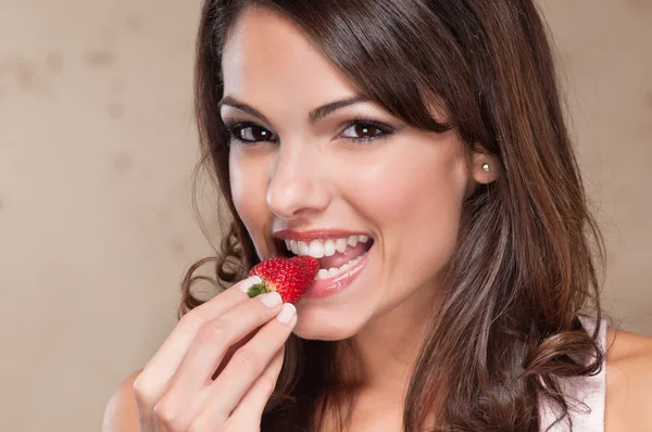 Hübsche junge Frau isst eine Erdbeere — Stockfoto