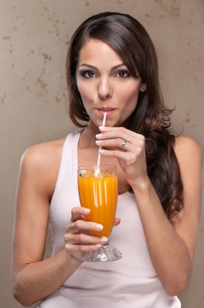 Kvinna som dricker apelsinjuice — Stockfoto