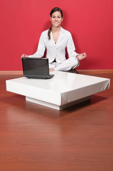 Mooie zakenvrouw zitten in yoga lotuspositie — Stockfoto