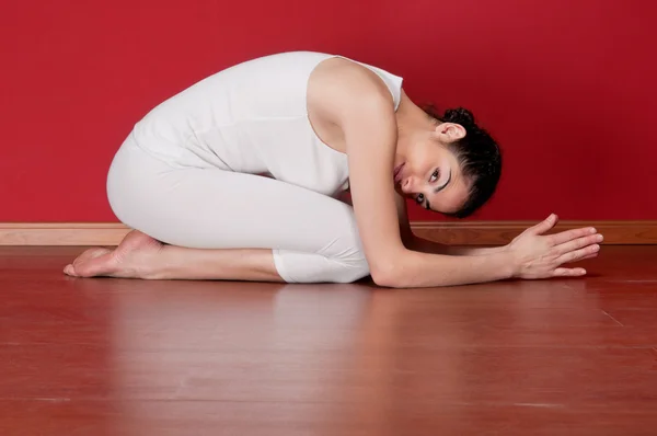 Jonge vrouw in een oefening kleding in een yoga-pose — Stockfoto
