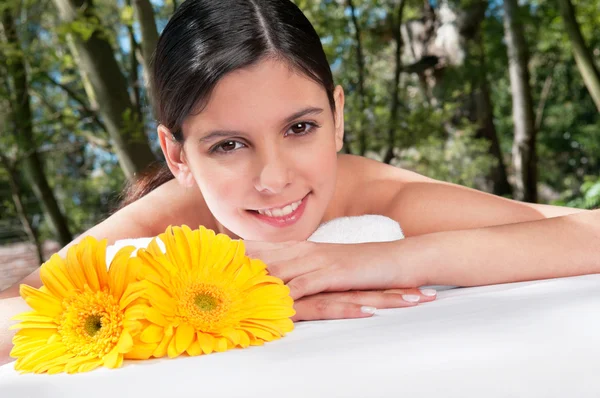 Όμορφη νεαρή γυναίκα με λουλούδια γύρω από — Φωτογραφία Αρχείου
