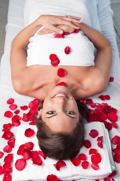 Leende vackra kvinna liggande på en massagebänk — Stockfoto
