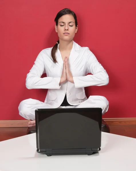 Businesswoman meditating in yoga lotus position — Stock Photo, Image