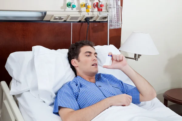 Пациент, использующий ингалятор астмы — стоковое фото