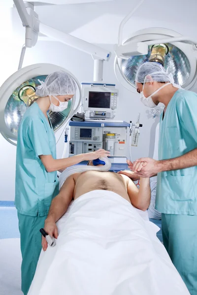 Пациента оперируют хирурги — стоковое фото