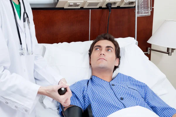 Доктор проверяет кровяное давление пациента — стоковое фото