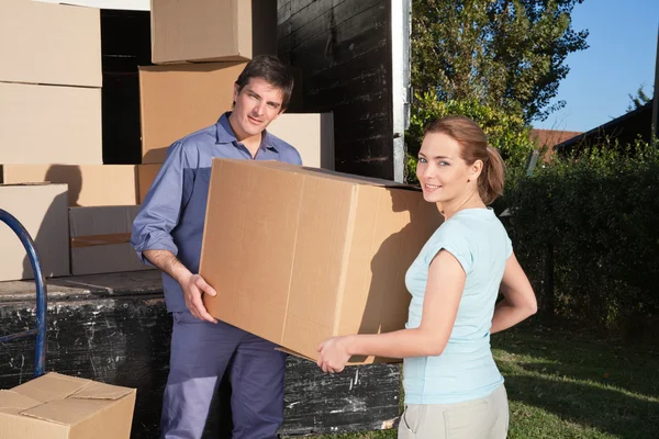 Portrait of couple carrying cardboard box — Stock Photo, Image
