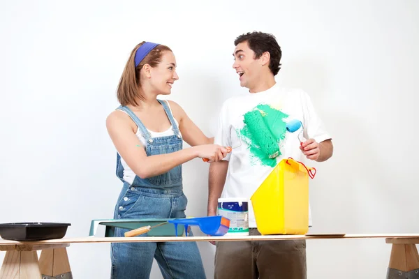 Happy woman having fun coloring her boyfriend's shirt — Stock Photo, Image