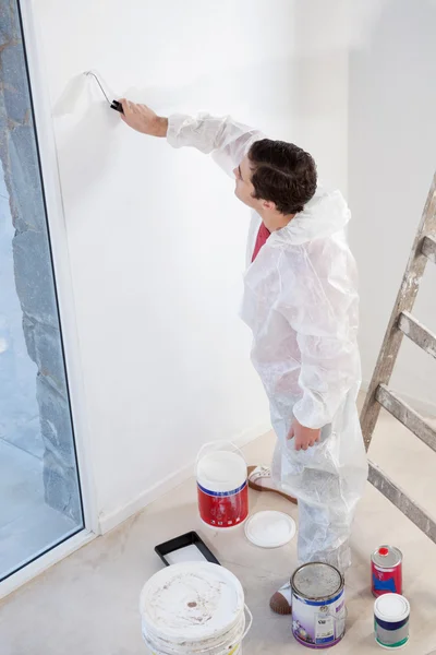 Trabalhador pintando a parede com um rolo — Fotografia de Stock