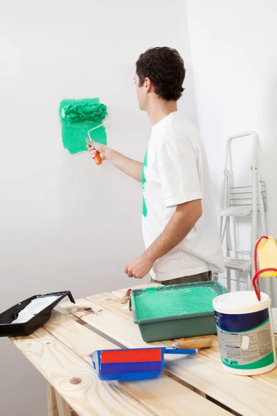 Casual homem pintando a parede de seu novo apartamento — Fotografia de Stock