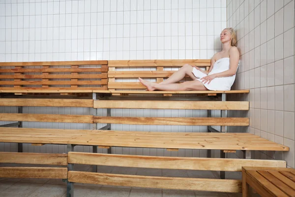 Mujer rubia joven relajándose en la sauna — Foto de Stock