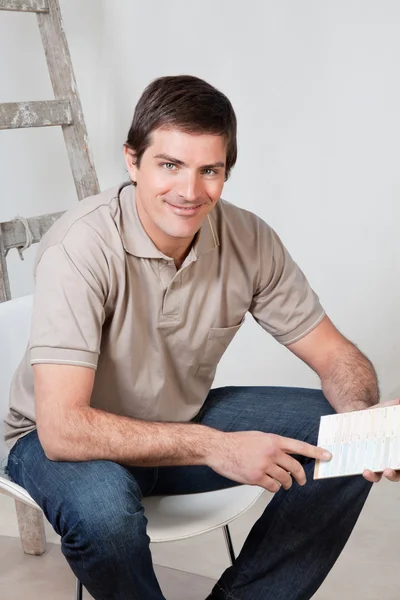 Mature man holding color swatch in his hand — Stock Photo, Image