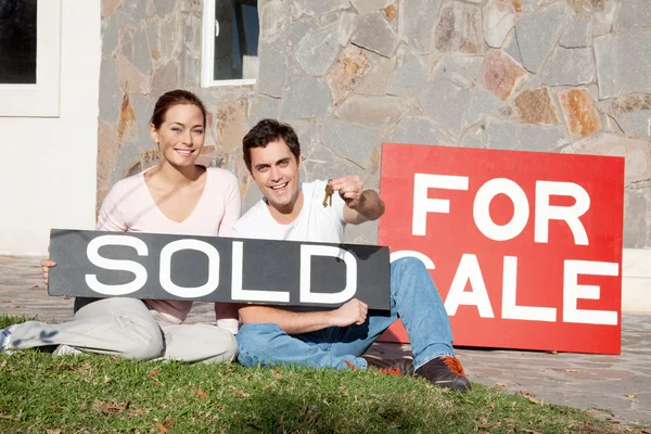 Lyckliga unga par med nyckel till deras nya hus — Stockfoto